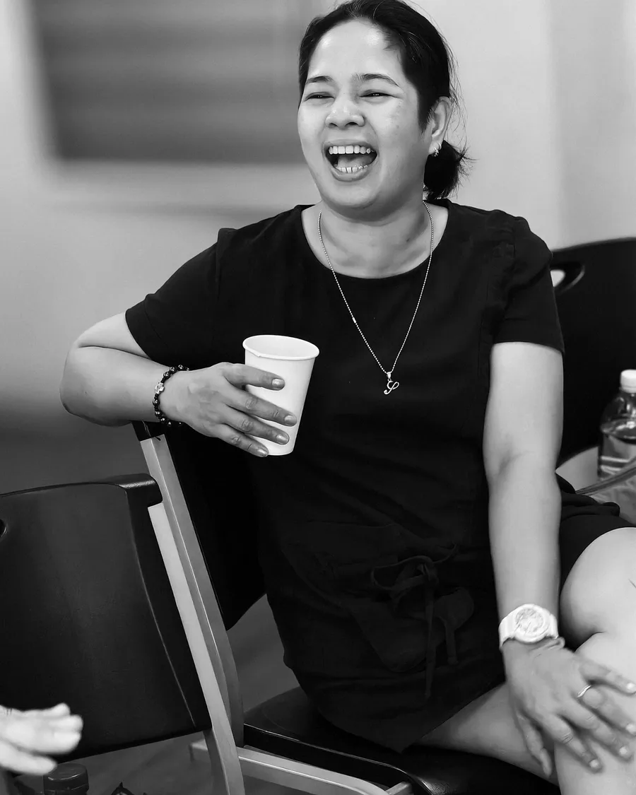 A choir member smiling with a drink in hand